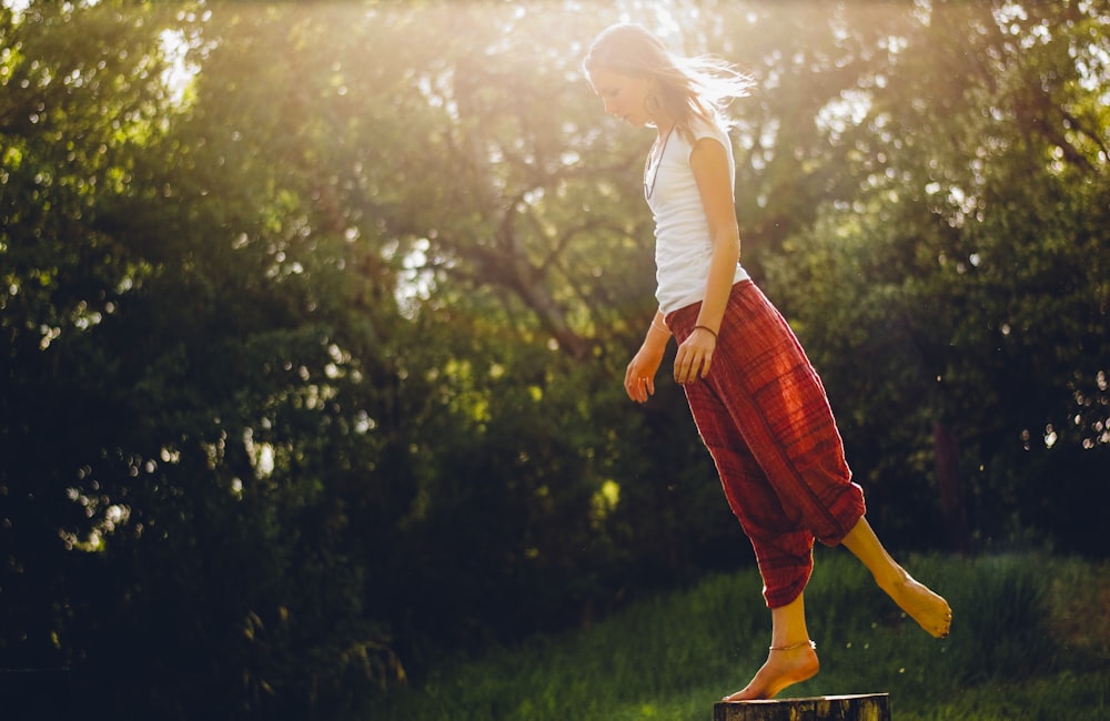 woman standing on wood log