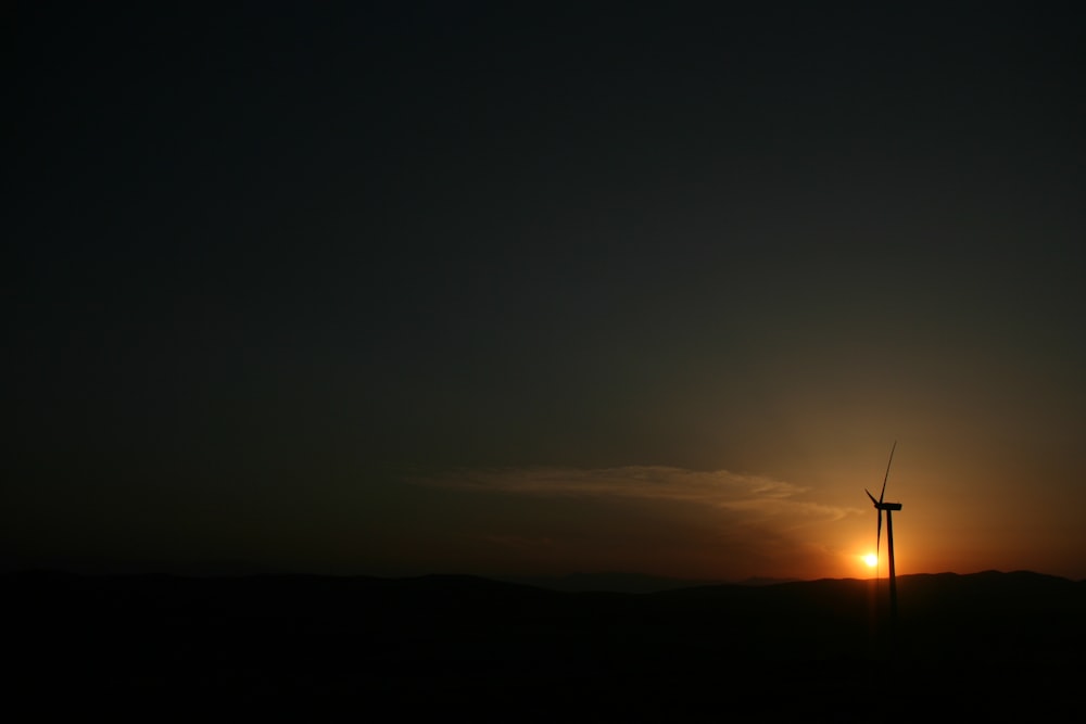 Silueta de molino de viento bajo la hora dorada