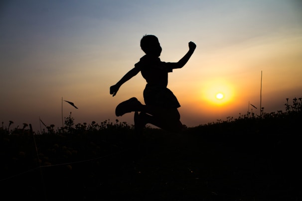 Evening training session with silhouettes of athletes jumping against the sunset.