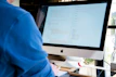A friendly technician repairing a computer in a bright office environment.