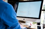 person facing monitor while typing during daytime