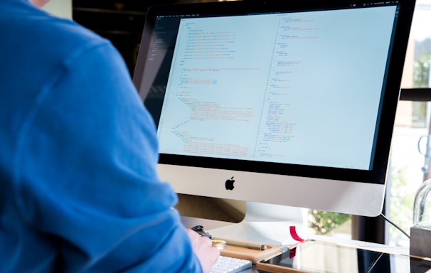 person facing monitor while typing during daytime