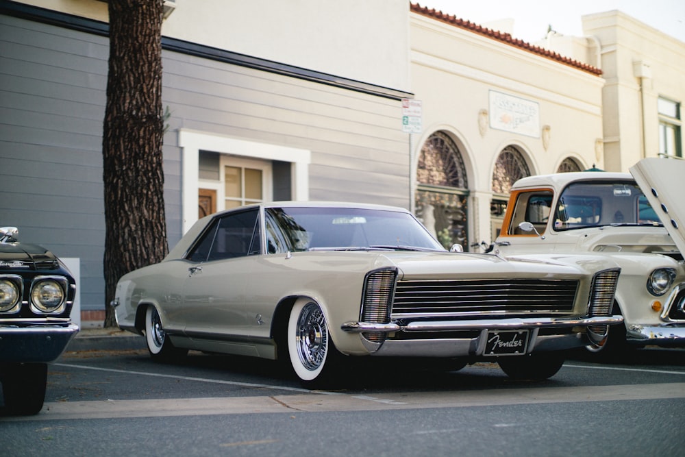 white coupe parked near tree and building