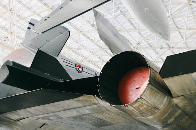 Close-up of a mechanic attaching a custom aircraft tag to a jet engine component inside a hangar.