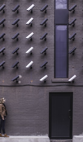 two women facing security camera above mounted on structure