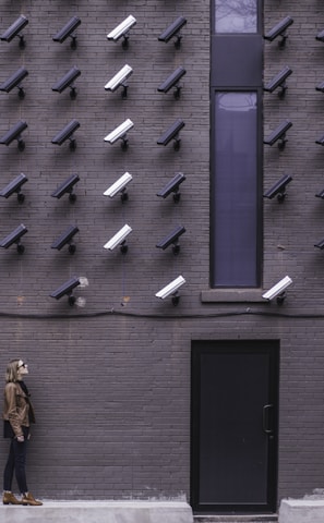 two women facing security camera above mounted on structure