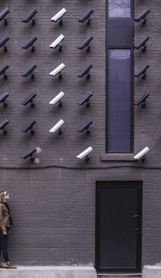 two women facing security camera above mounted on structure