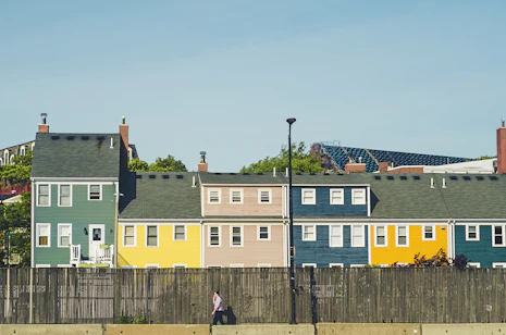 man walking beside multicolored apartments