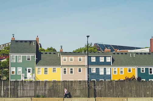 man walking beside multicolored apartments