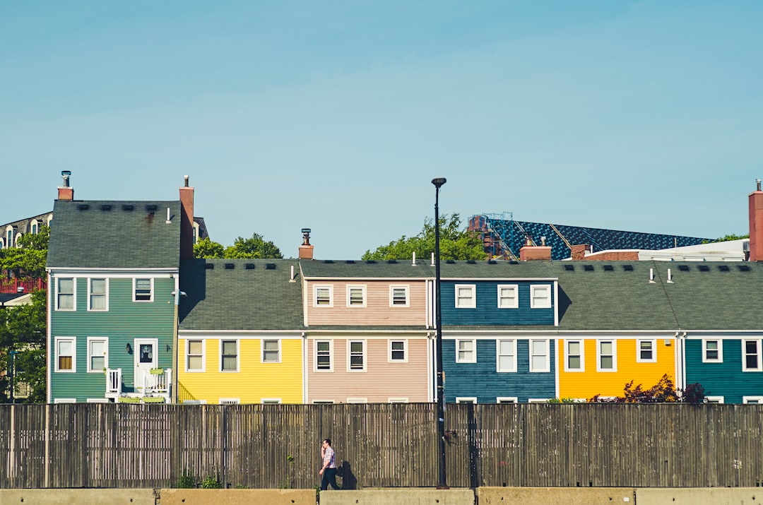 man walking beside multicolored apartments