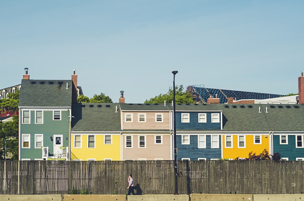 man walking beside multicolored apartments