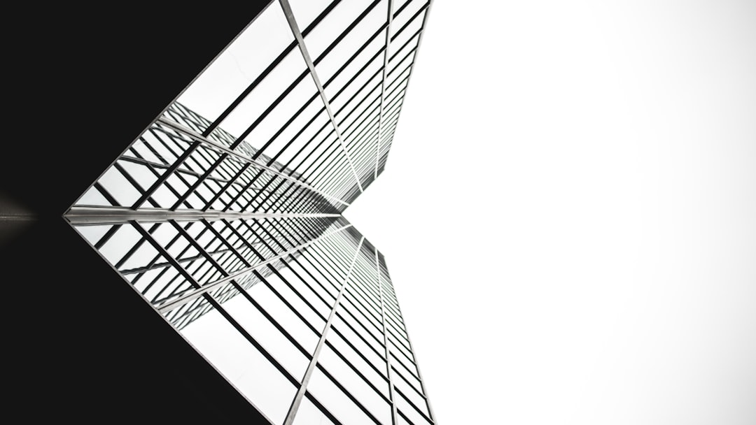 low angle photo of mirror glass building, monochrome calgary tower