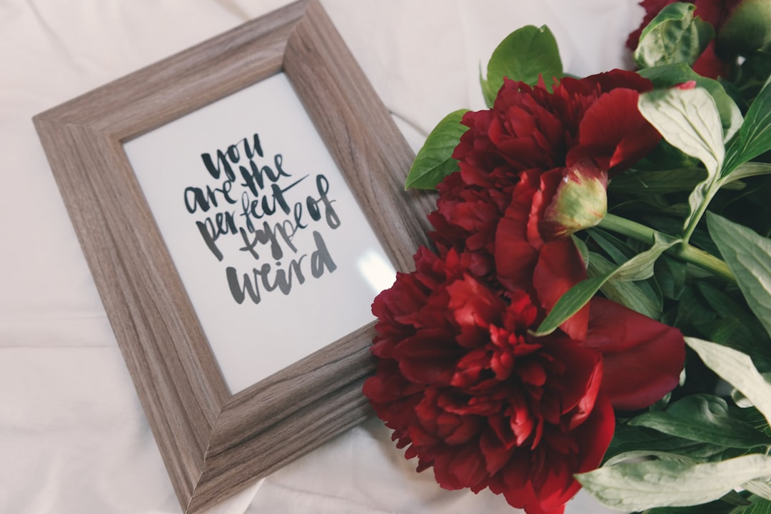 Flowers with framed art that reads 