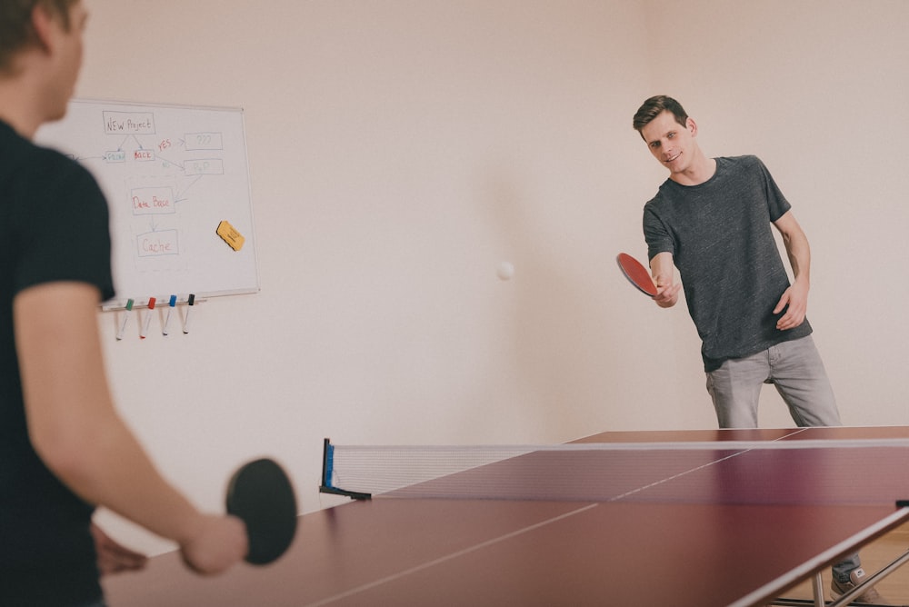 Zwei Männer spielen Tischtennis im Raum