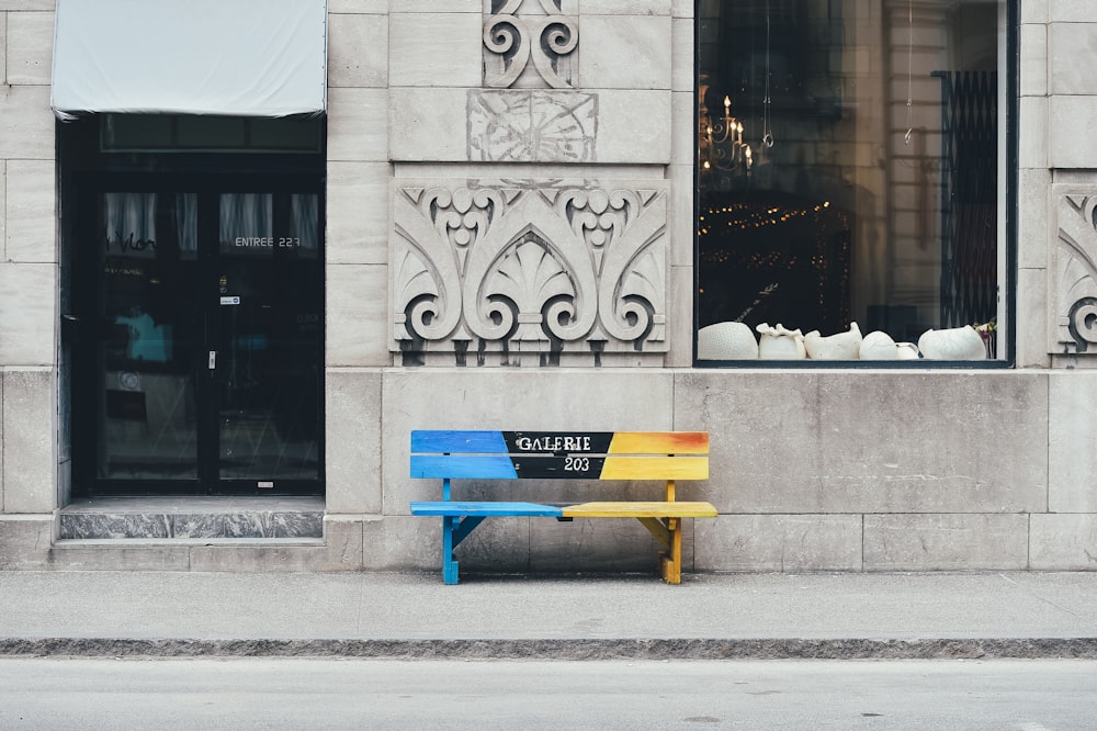 blue and brown wooden bench on sidewalk