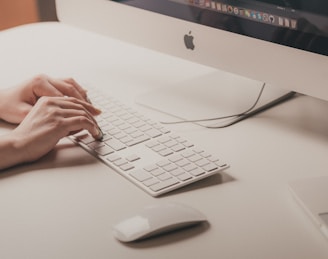 person typing on Apple keyboard