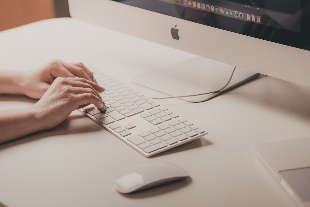 Person, die auf der Apple-Tastatur tippt