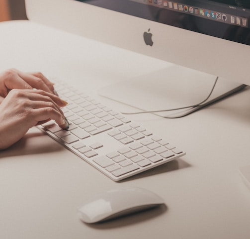 person typing on Apple keyboard