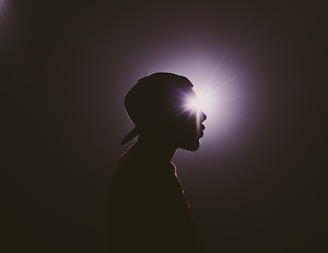 silhouette photography of man wearing cap