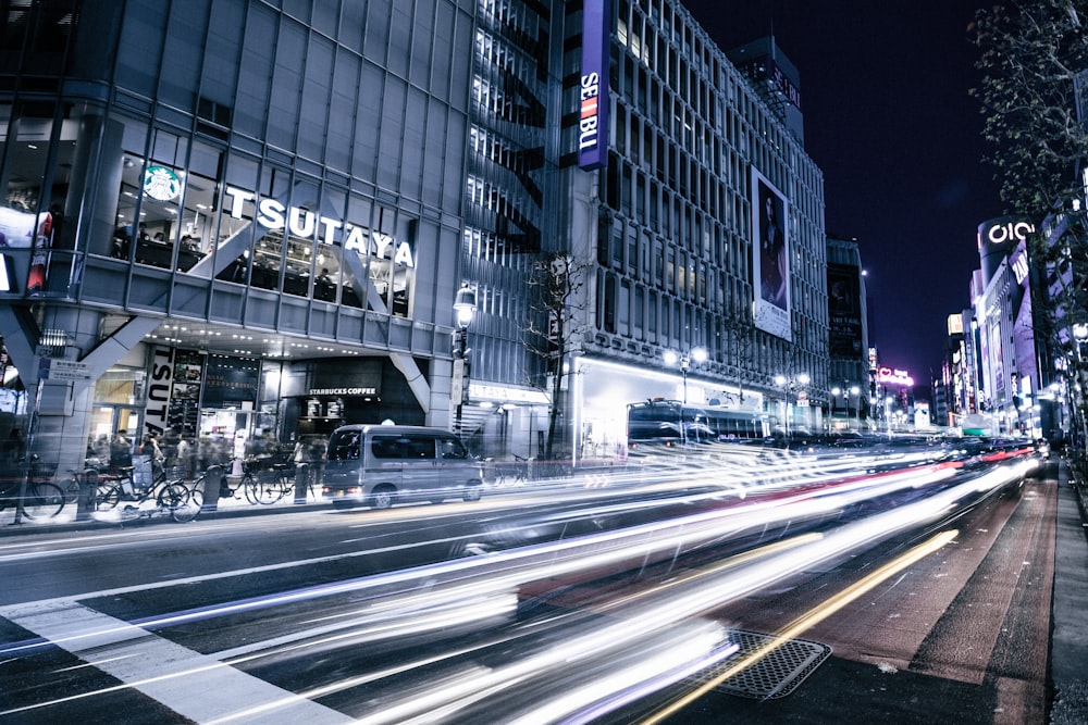 time-lapse photography of asphalt road near buildings during nighttime