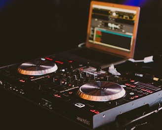 black DJ turn table next to laptop computer