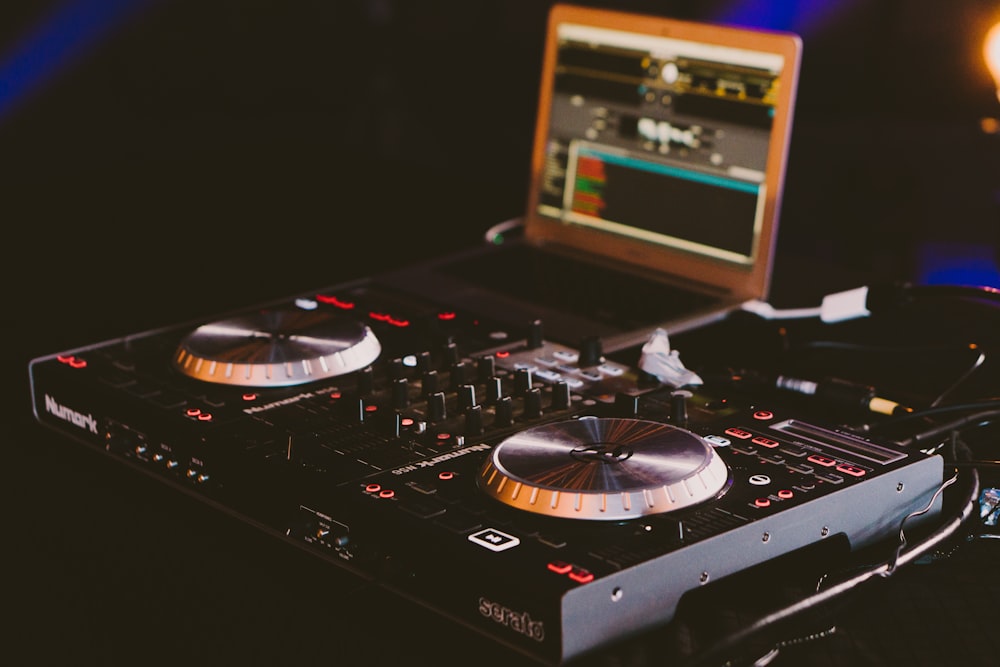 black DJ turn table next to laptop computer