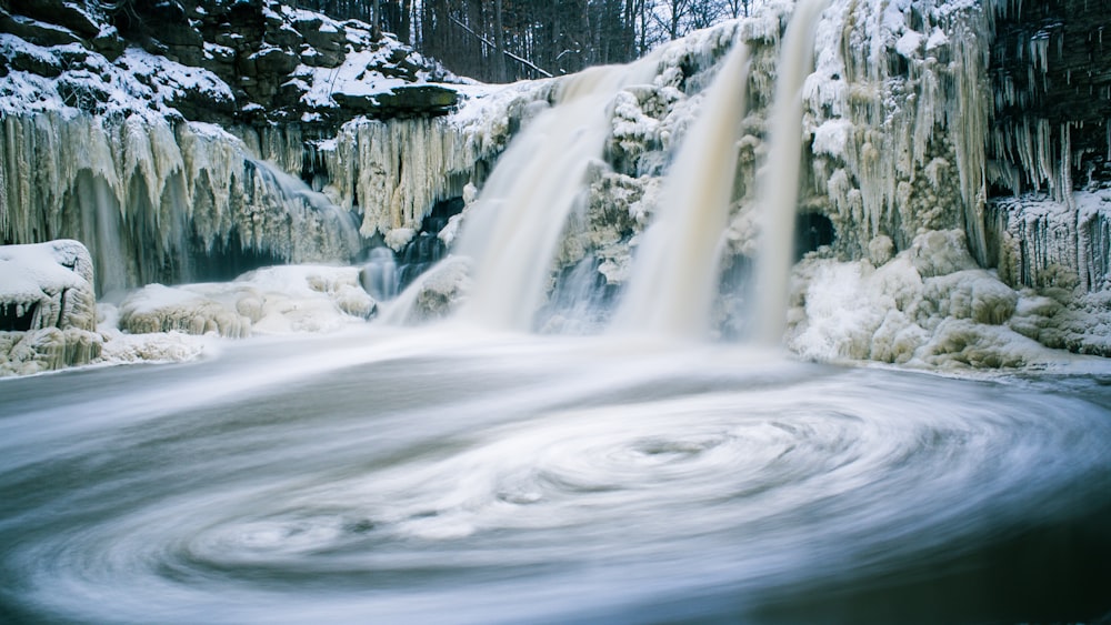 fotografia timelapse de cachoeiras com neve derretida
