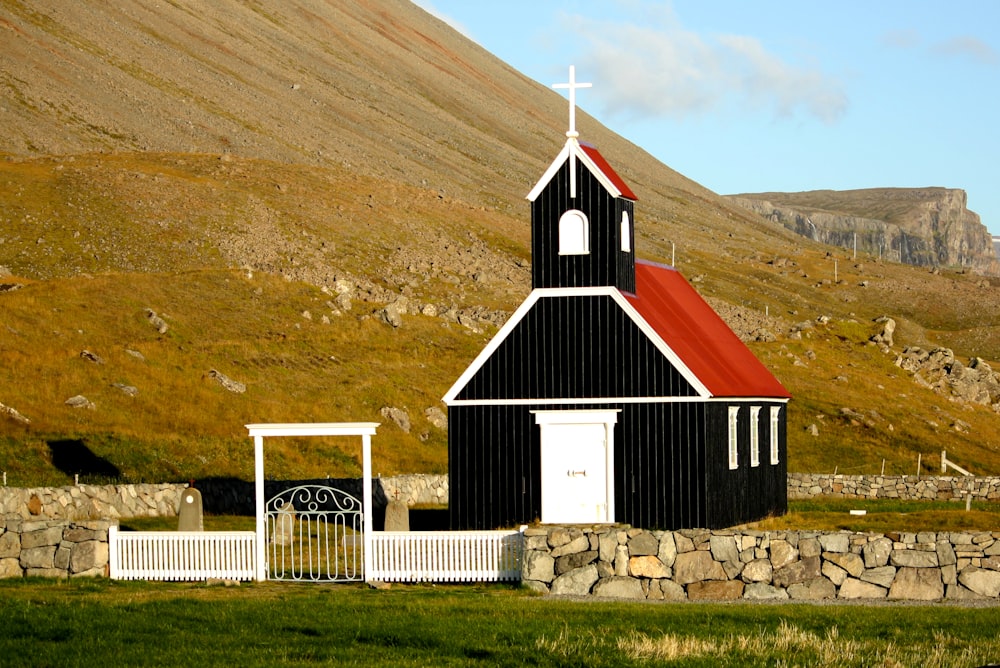 Église noire et rouge près des chaînes de montagnes