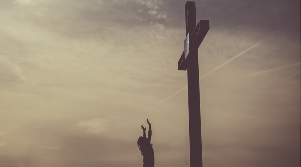 Ein Kreuz mit einem bewölkten Himmelshintergrund.