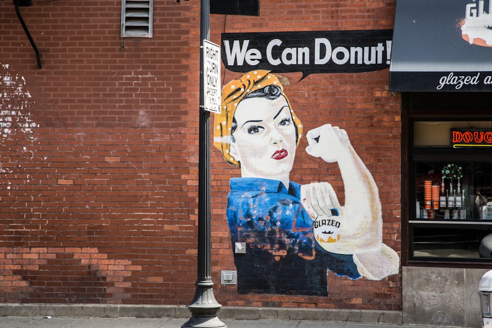 Um meme feminista pintado em uma parede com a legenda: "We Can Donut!"