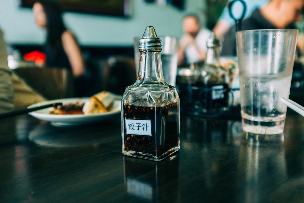 clear glass condiments container on black wooden board