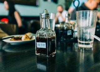 clear glass condiments container on black wooden board