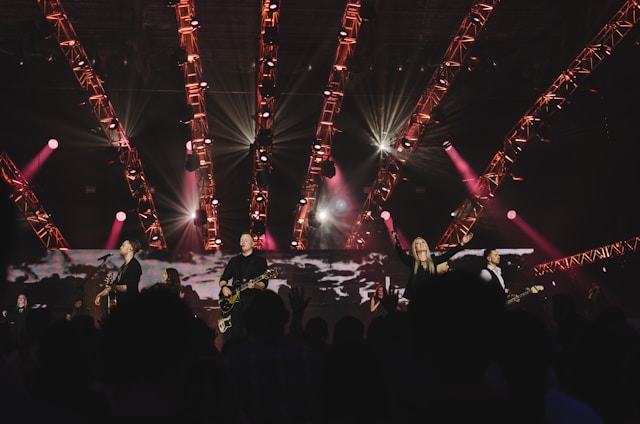 Band performing live on stage with enthusiastic crowd in a festive atmosphere.