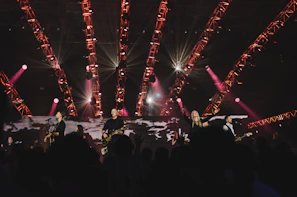 Band performing live on stage with vibrant lighting and engaged crowd.