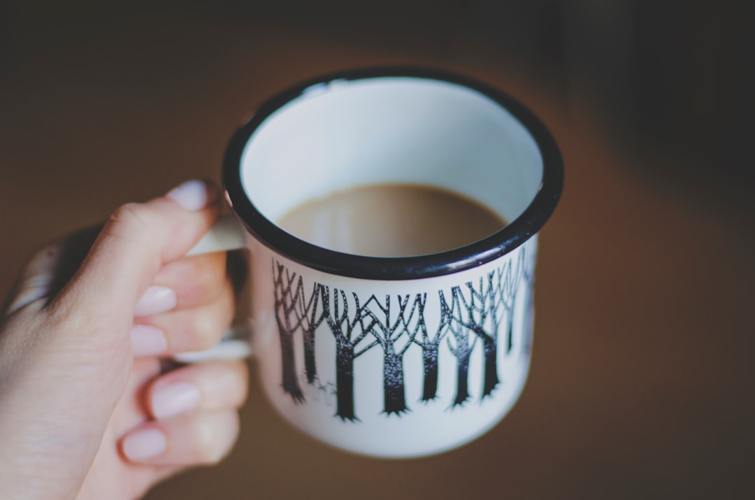 white and black ceramic mug filled with coffee