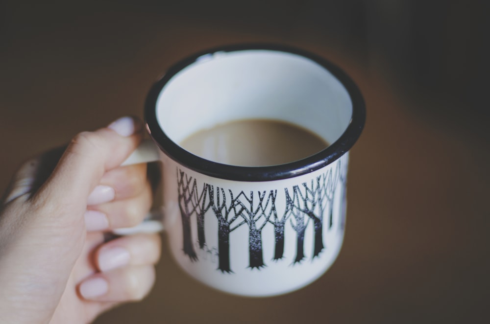 white and black ceramic mug filled with coffee