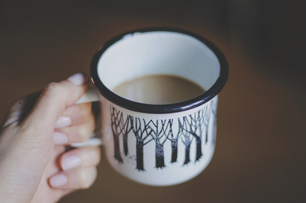 Caneca de cerâmica branca e preta recheada com café