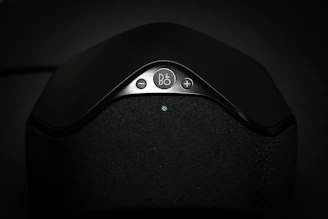 Close-up of a sleek Dante PoE speaker with visible DSP controls.