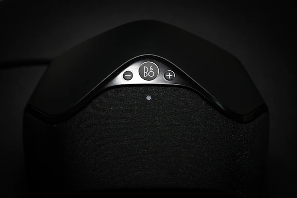 Close-up of a sleek Dante PoE speaker with visible DSP controls.
