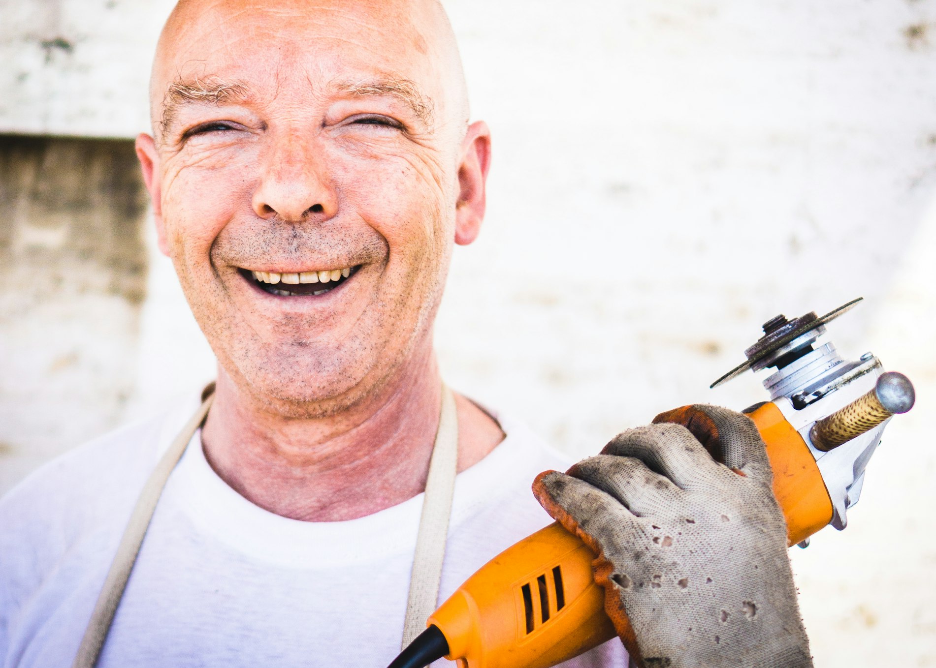 Man smiling while holding a power drill