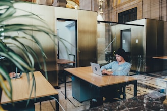 Photo of Vinay Thakur working on a laptop in a bright, modern office space.