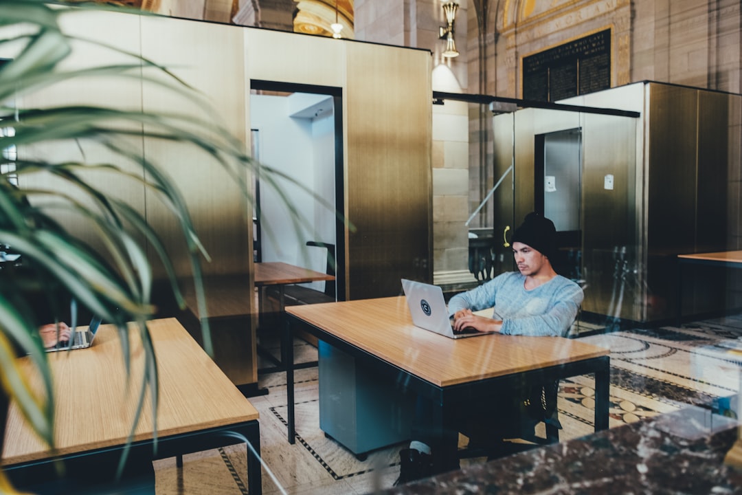 man using a gray laptop computer, Desks in an open office space