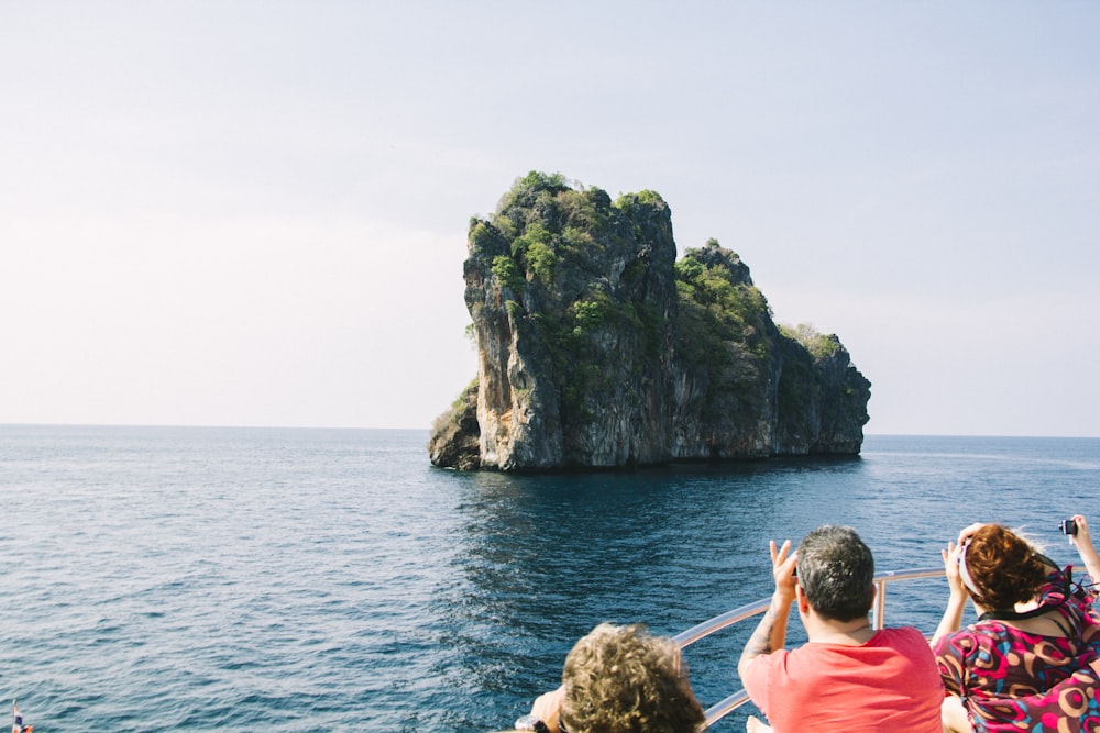 a group of people on a boat looking at an island