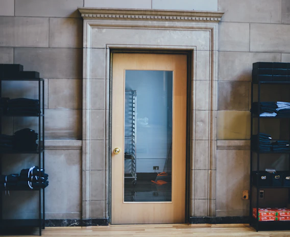 A wooden multi-purpose wardrobe featuring drawers and a mirror on the door.