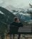 man sitting on bench on top of the mountain