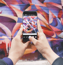 person holding Android smartphone and taking a photo of abstract wall during daytime