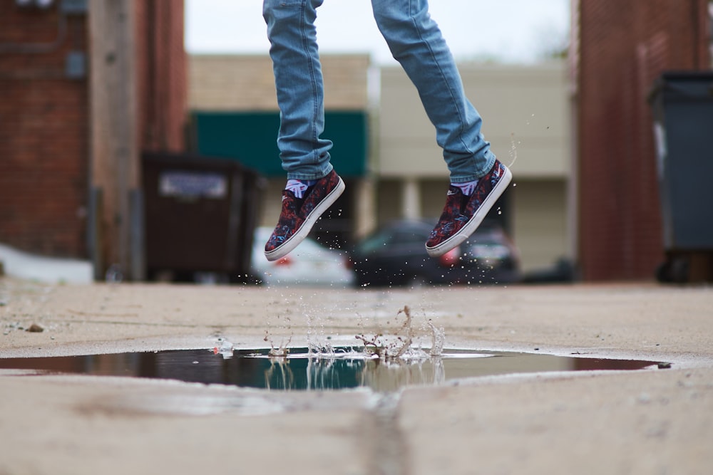 person jumping over body of water