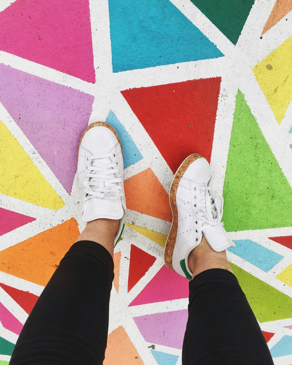 person wearing white adidas Stand Smith sneankers