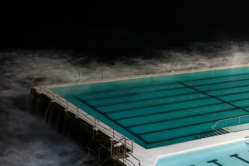 piscina retangular rodeada por névoa