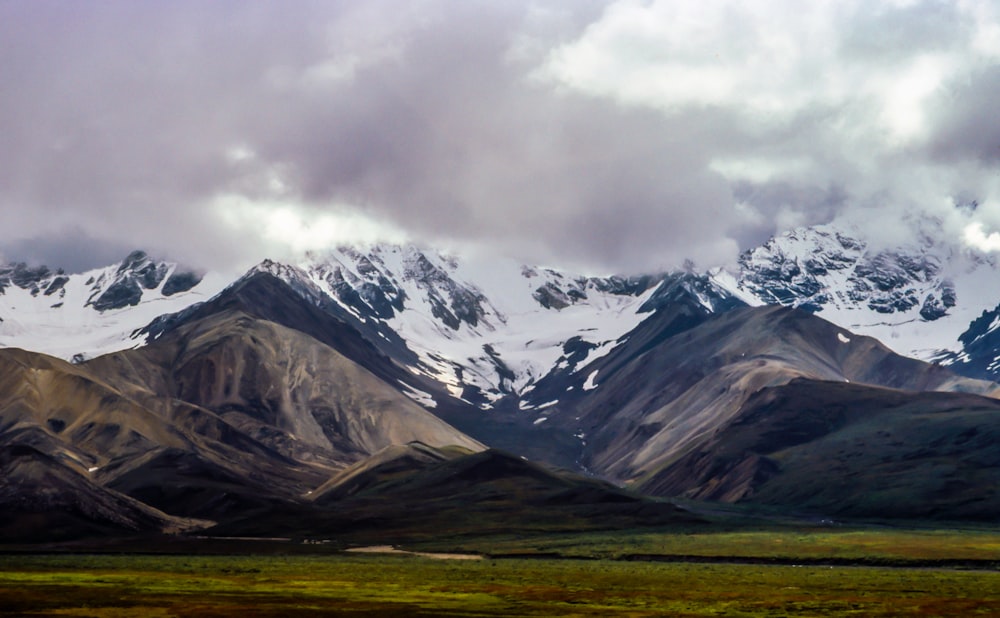 gray mountain range covered with snows at daytime